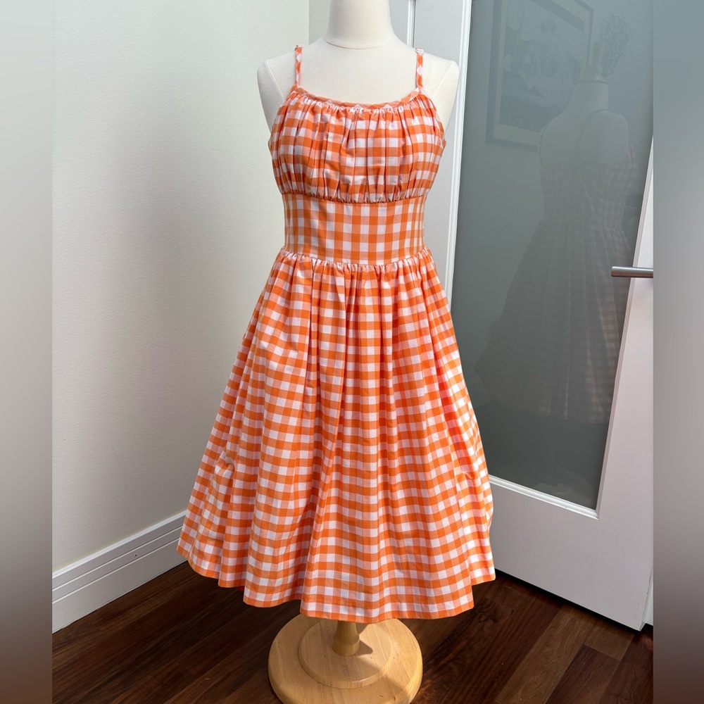 Darling orange gingham pin up swing dress. Gathered shelf bust and fitted waist.